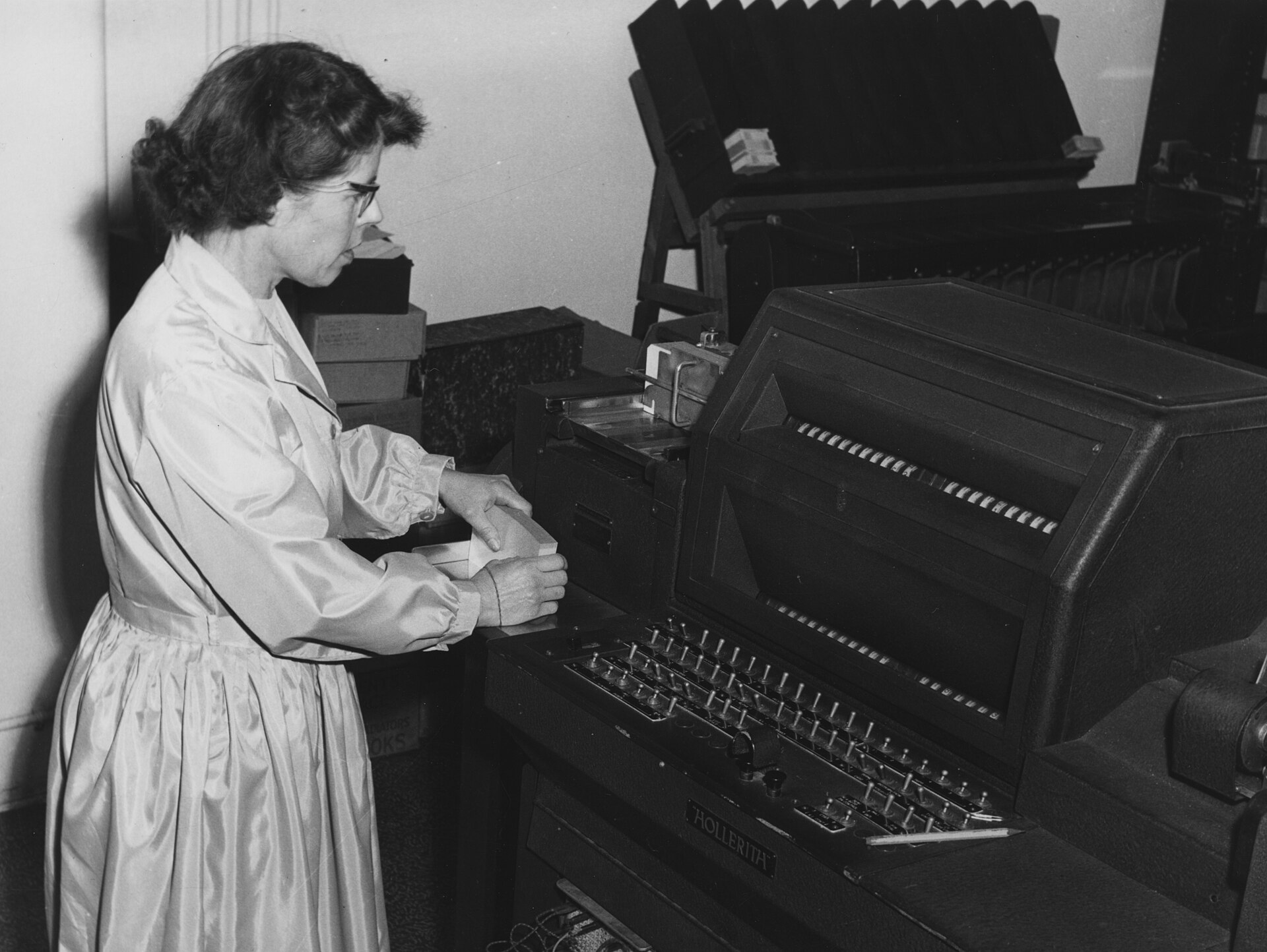 Black-and-white photo from 1964: a woman operating a punched card machine